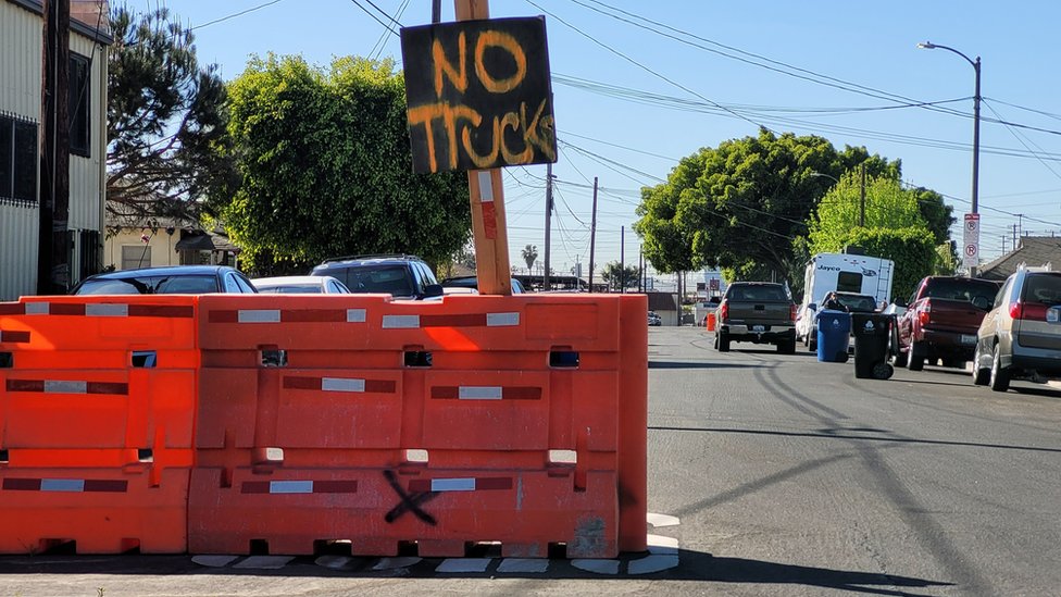 Cartel de No Trucks (sin camiones) junto a barricadas.