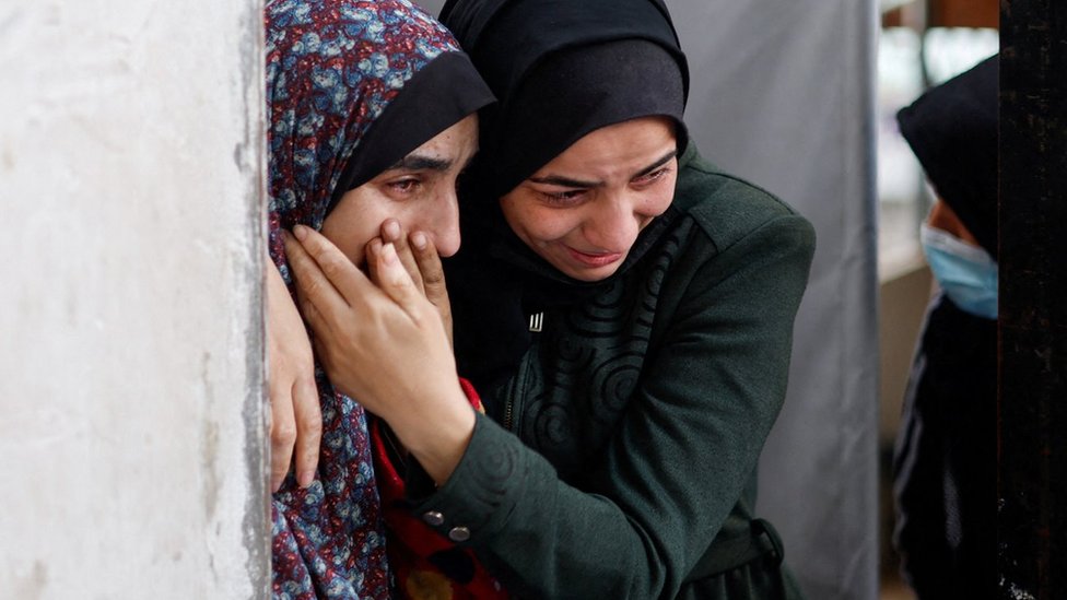 Palestinian women react at the Abu Yousef Al-Najjar hospital in Rafah, in the southern Gaza Strip (12 February 2024)