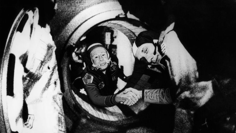Commander of the Soviet crew of Soyuz, Alexei Leonov (L) and commander of the US crew of Apollo, Thomas Stafford (R), shake hands after the Apollo-Soyuz docking manoeuvres on 17 July 1975