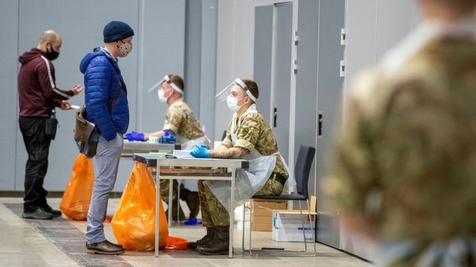Soldiers talk to people at The Exhibition Centre, in Liverpool, which has been set up as a testing centre as part of the mass coronavirus disease
