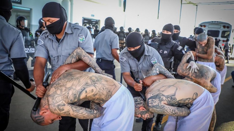 Prison agents guard the gang members as they are processed upon arrival after 2,000 gang members were transferred to a terrorist detention center.
