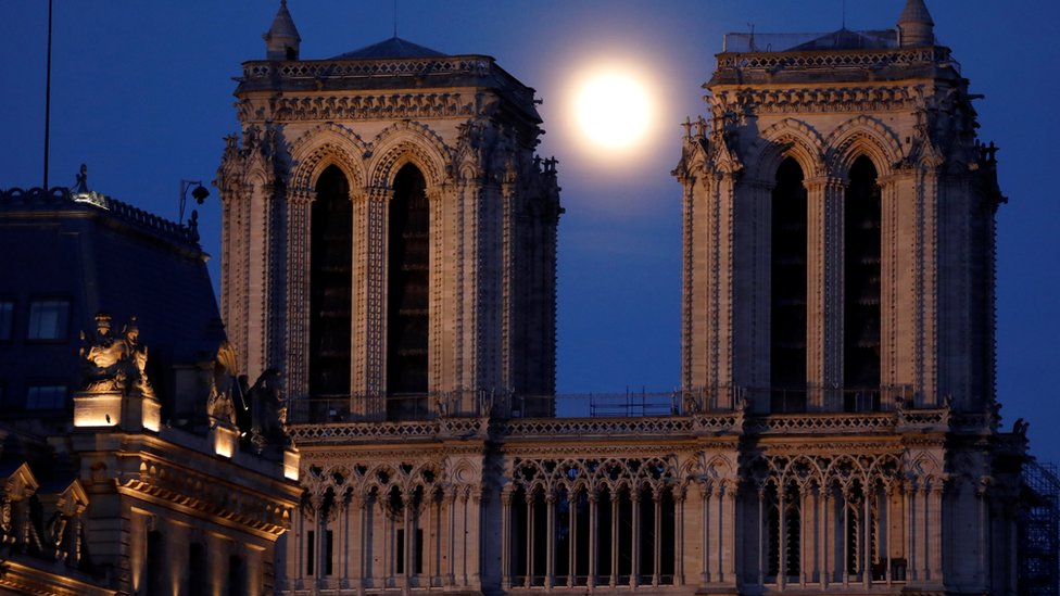 The pink supermoon rises between the two towers of Notre Dame Cathedral