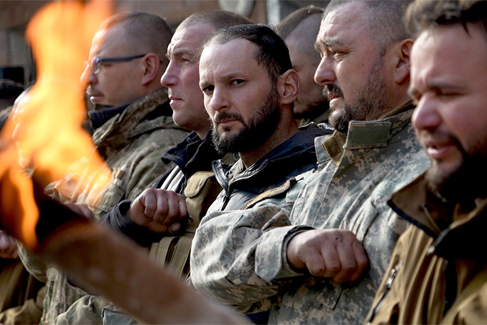 Soldados ucranianos rinden homenaje a uno de los suyos en un funeral militar.