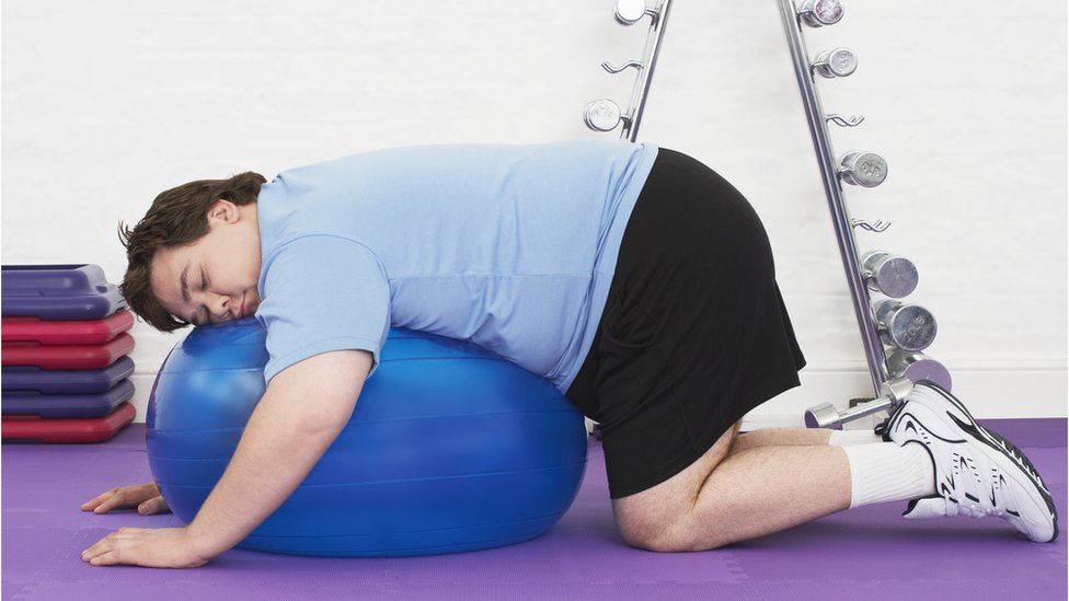 Толстяк отдыхает на мяче для упражнений
