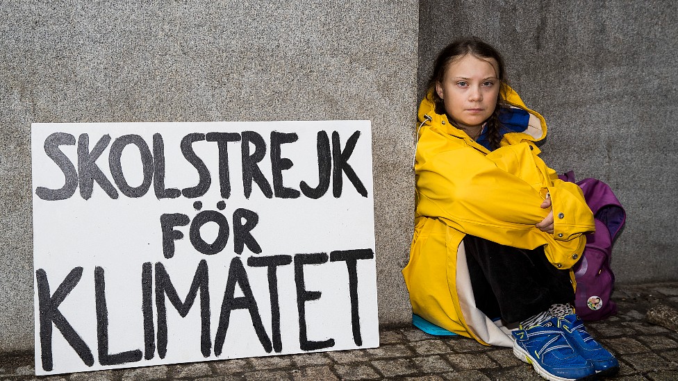 Greta Thunberg con un cartel que dice "Huelga por el clima"