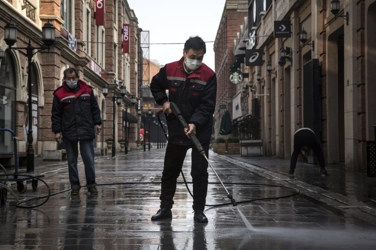 Trabajadores limpian una calle de Wuhan
