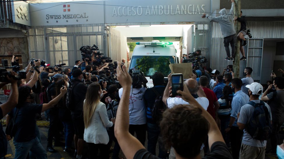 Hinchas reunidos a la salida de la ambulancia de Maradona.