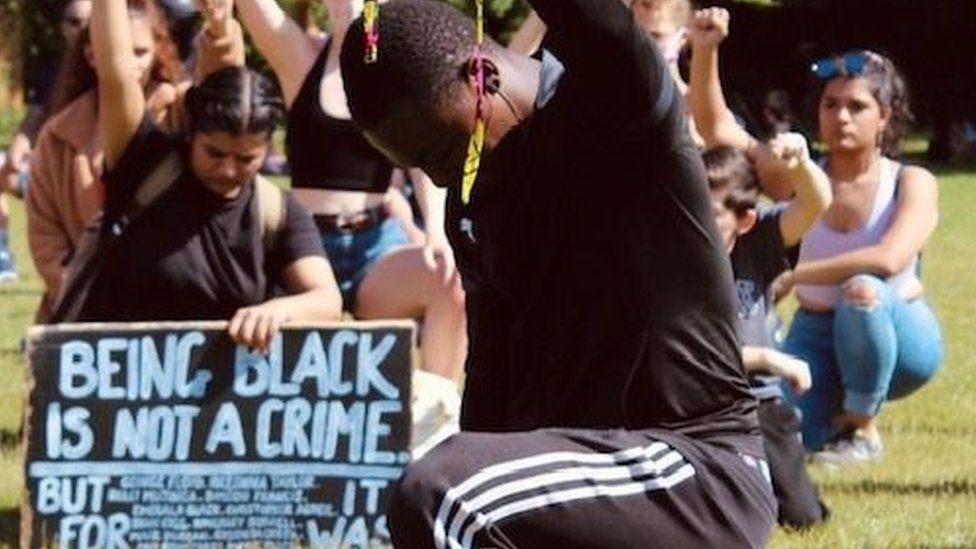 Мужчина преклонил колени на акции протеста Chelmsford Black Lives Matter