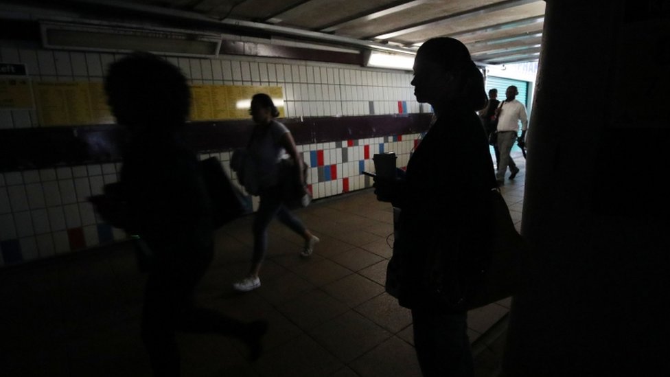 Люди, идущие в темноте в пассажирском туннеле под станцией Clapham Junction