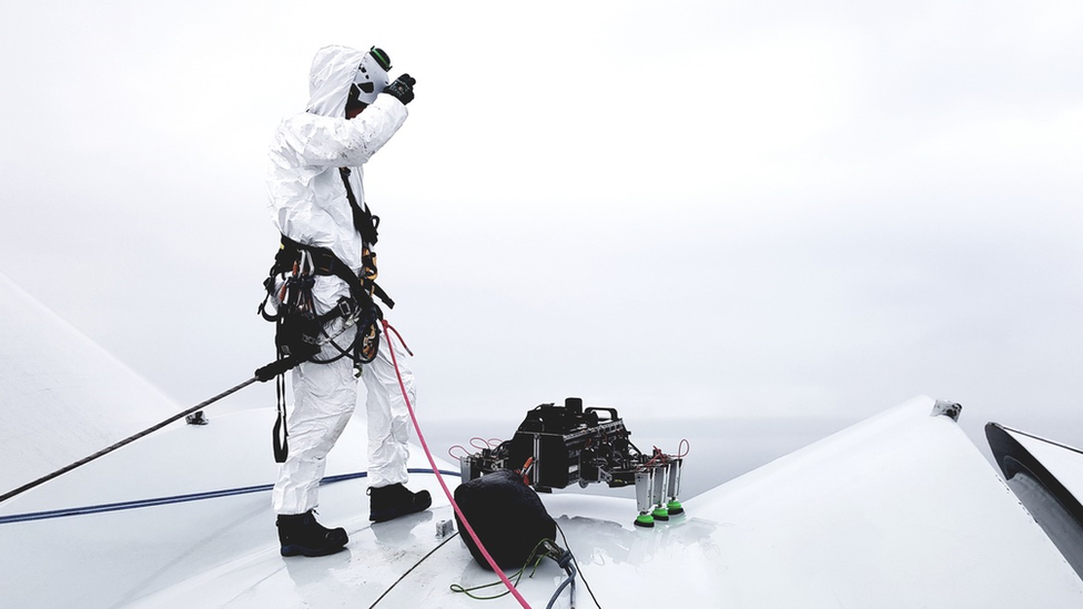 BladeBUG robot on a wind turbine with a man operating the device