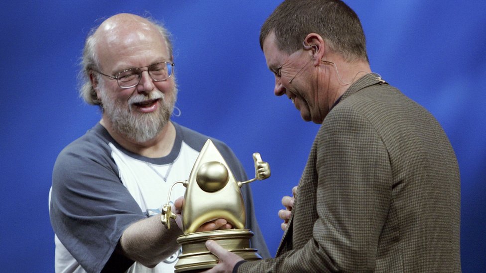 Председатель правления Sun Microsystems Скотт МакНили (справа) получает награду Duke от вице-президента Sun и научного сотрудника Джеймса Гослинга во время выступления на конференции JavaOne в 2006 году