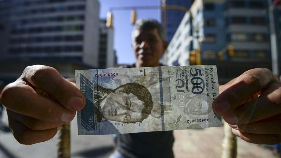Otros gobiernos como el de Rusia y Dubái también han anunciado monedas digitales. Hombre con billete