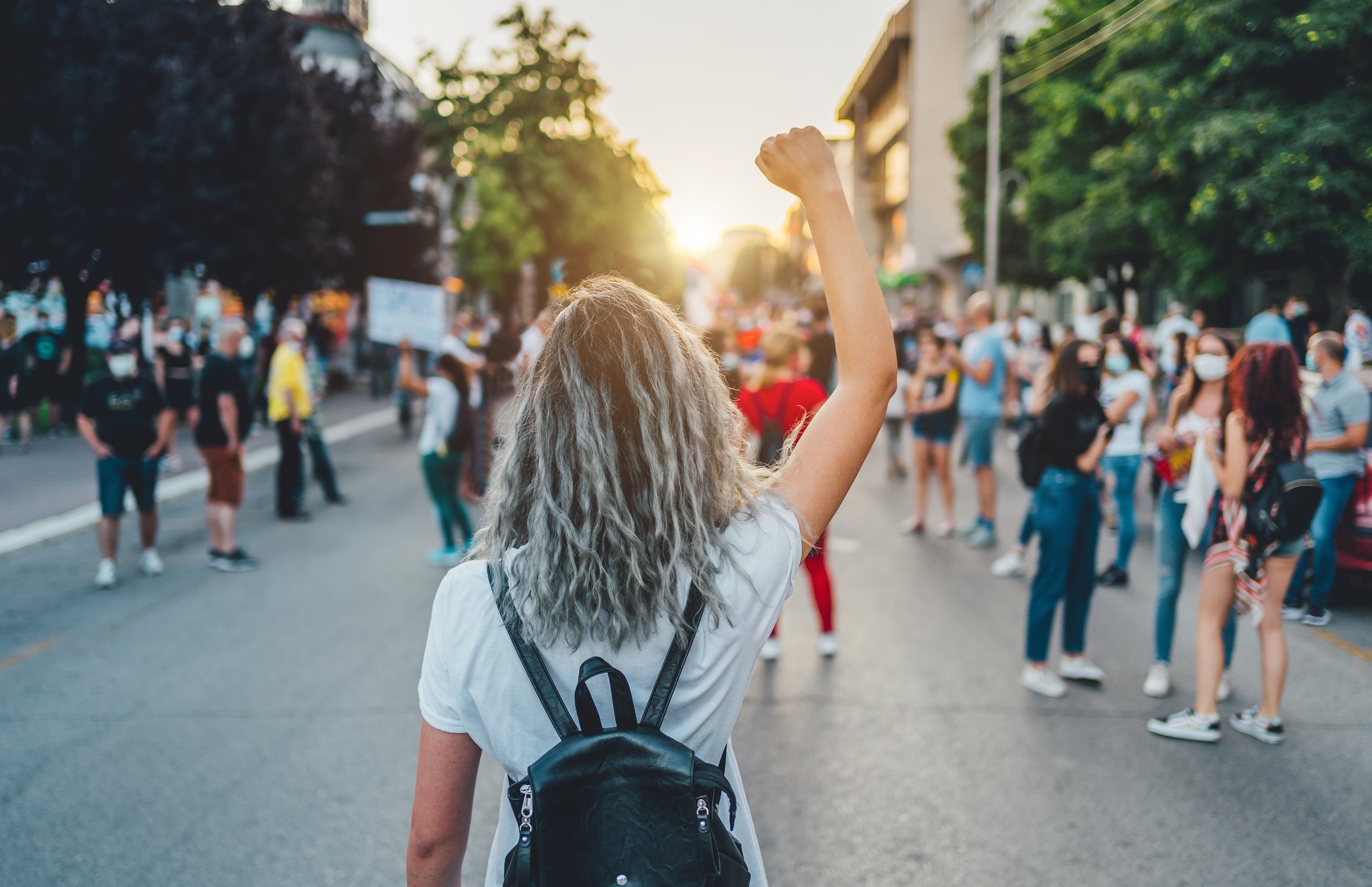 Mulher de costas com punho elevado em manifestação