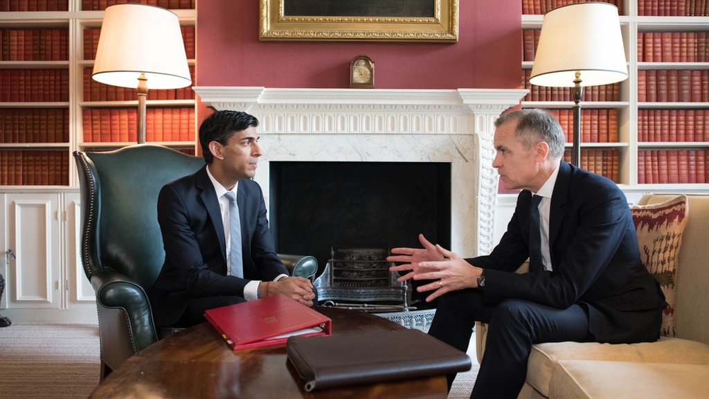 Марк Карни беседует с канцлером Великобритании Риши Сунаком перед принятием бюджета.