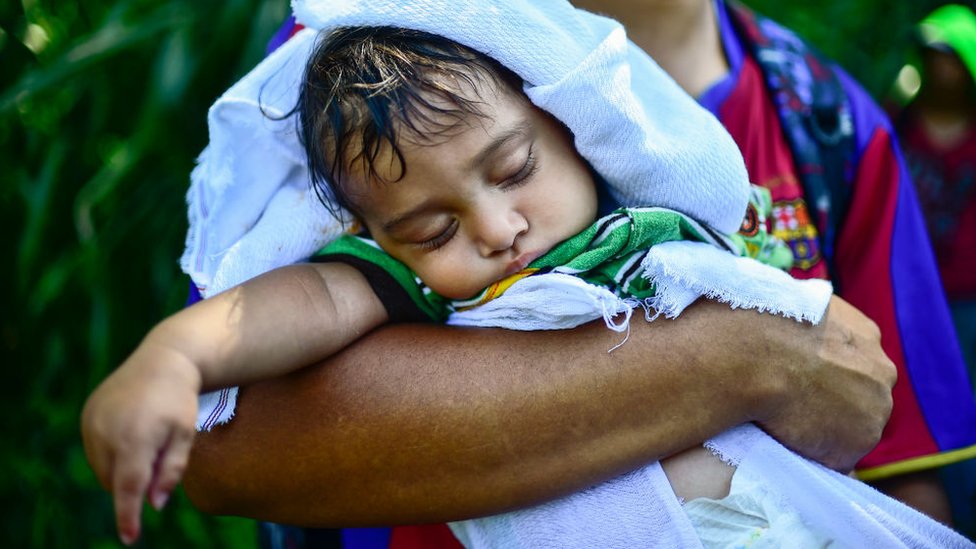 Un niño es cargado por un adulto