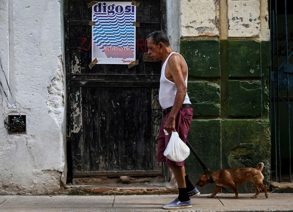 Hombre en Cuba junto a un cartel favorable al código de las familias.