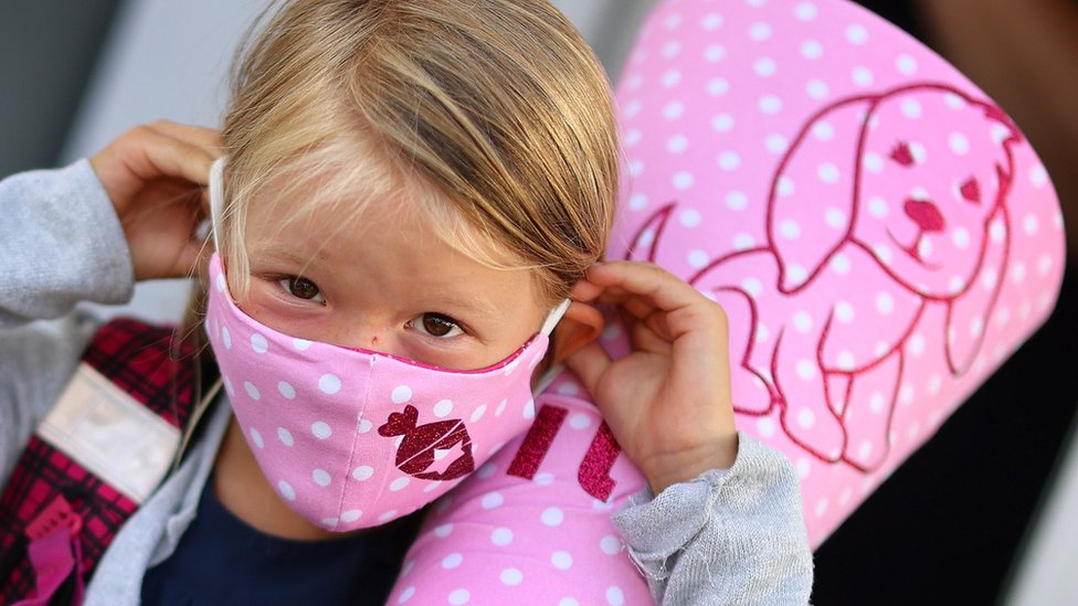 A six-year-old schoolgirl on her way to school in a facemask in Germany