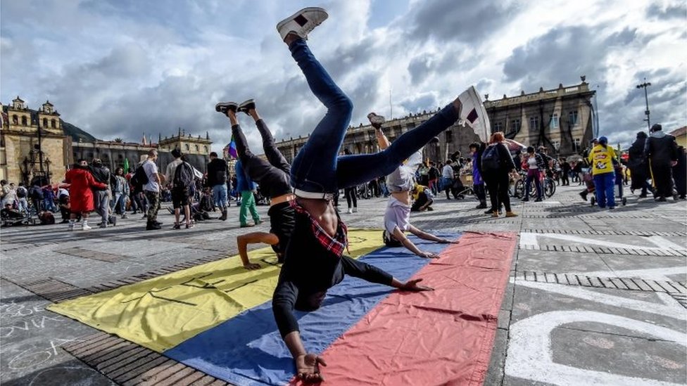 Молодые люди танцуют во время акции протеста против правительства президента Колумбии Ивана Дуке во время национальной забастовки в Боготе 27 ноября 2019 г.