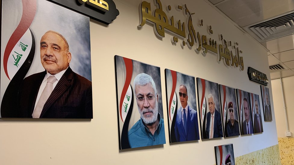 Фотография лидера иракских ополченцев аль-Мухандиса (второй слева) на стене базы Союза III