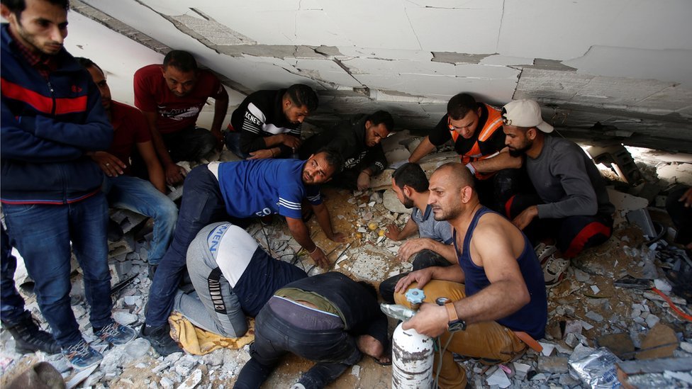 Men gather around rubble looking for survivors