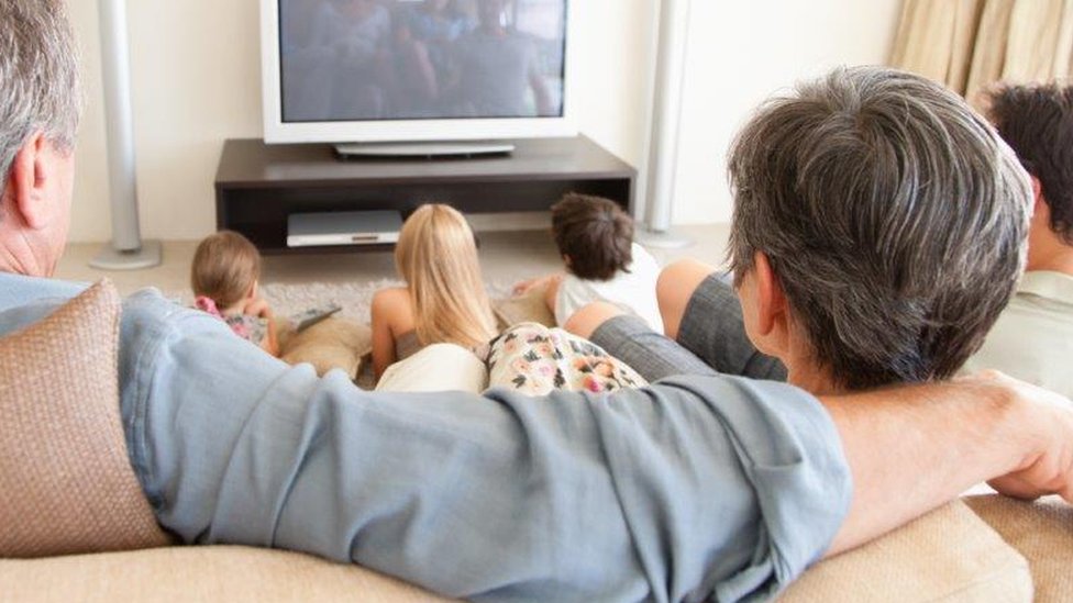 Многодетная семья смотрит телевизор