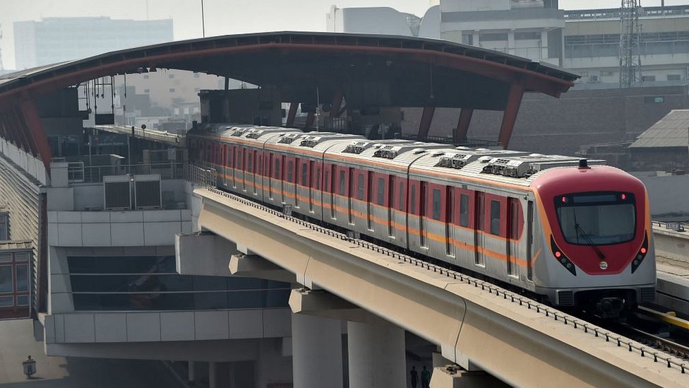 Поезд ходит по недавно построенной станции метро Orange Line в Лахоре