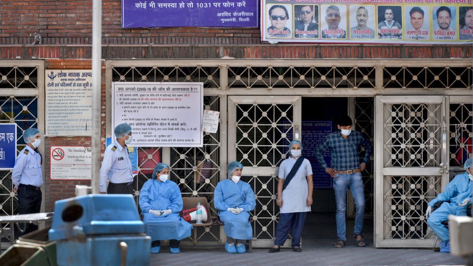Врачи и другой медицинский персонал были замечены в СИЗ за пределами отделения неотложной помощи на девятнадцатый день 21-дневной общенациональной изоляции для проверки распространения коронавируса возле больницы Лок Наяк Джай Пракаш Нараян (LNJP) 12 апреля 2020 года в Нью-Дели, Индия.