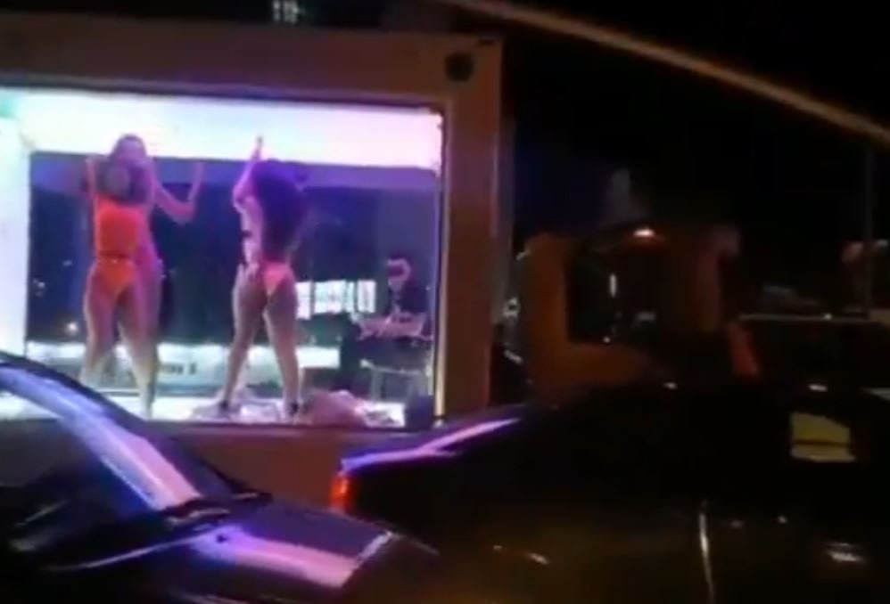 Люди танцуют в прозрачном трейлере в пробке