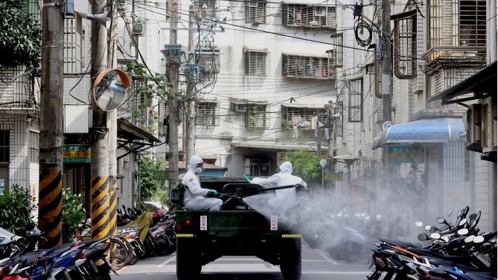 身穿防護服的軍人在台北街頭消毒。