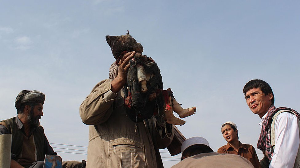 Un hombre con el cuerpo de un bebé muerto en un bombardeo en 2016.
