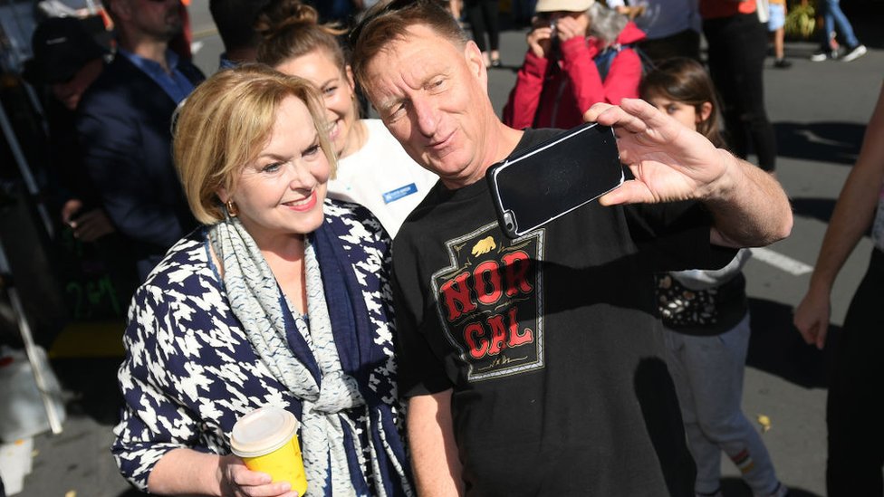 Para Collins es fundamental recuperar su base. Un seguidor se toma un selfie con Judith Collins.