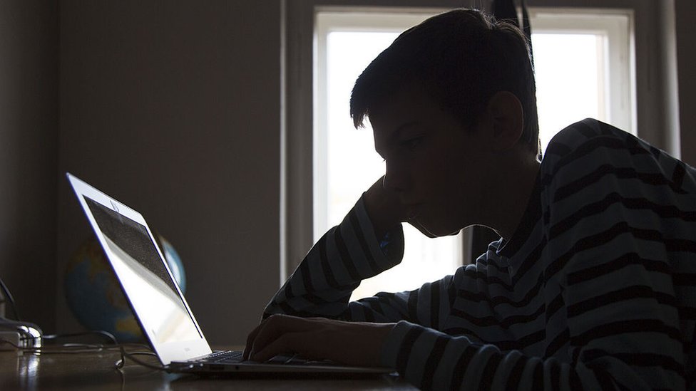 Internet nos hace sentirnos "invisibles" frente a los demás, por eso somos más abiertos a la hora de compartir nuestras cosas. sombra de un joven en internet