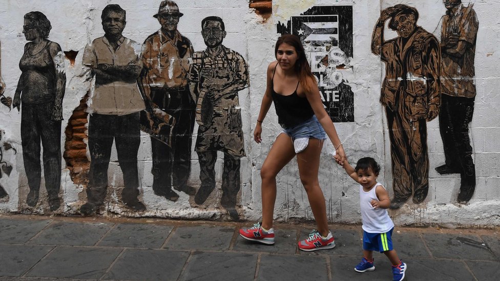 La tasa de natalidad en la isla ha disminuido como consecuencia de la migración a EE.UU. de miles de puertorriqueños. Una mujer puertorriqueña lleva de la mano a un niño.