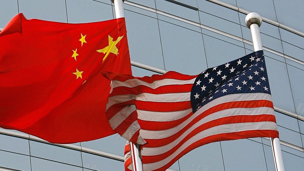 Las banderas de EE.UU. y China en las afueras de un edificio comercial en Beijing