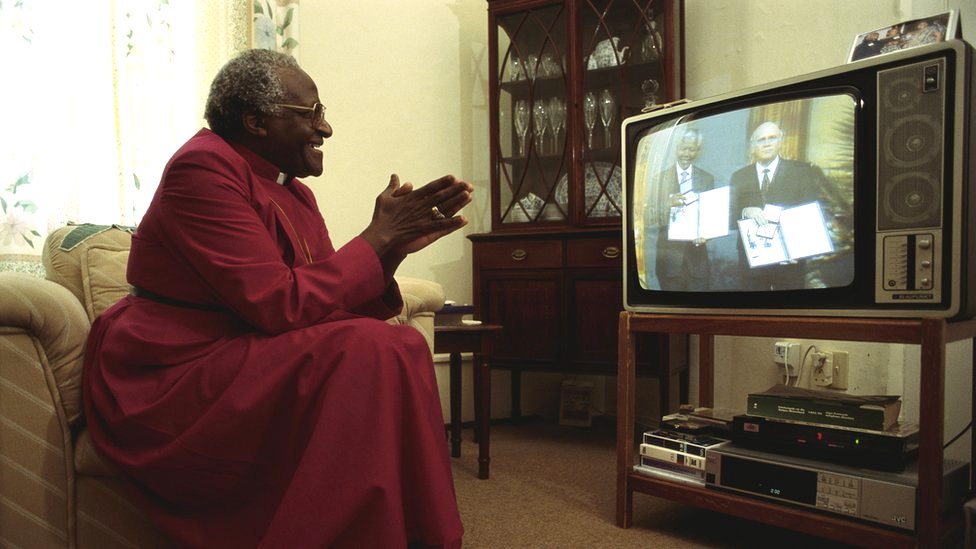 Archbishop Desmond Tutu applauds as he watches Nelson Mandela and South African President FW de Klerk receive their Nobel Peace Prize for ending Apartheid in South Africa