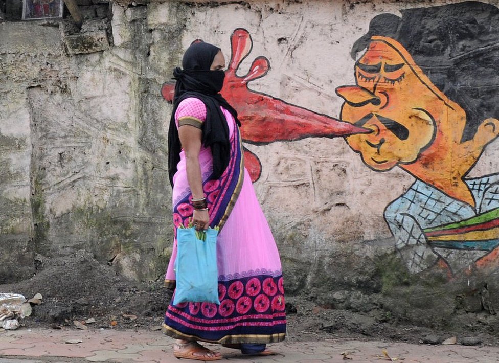 A woman walks past a graffiti in Mumbai. Municipal corporation is creating awareness about the dangers of spitting in public places through graffiti.