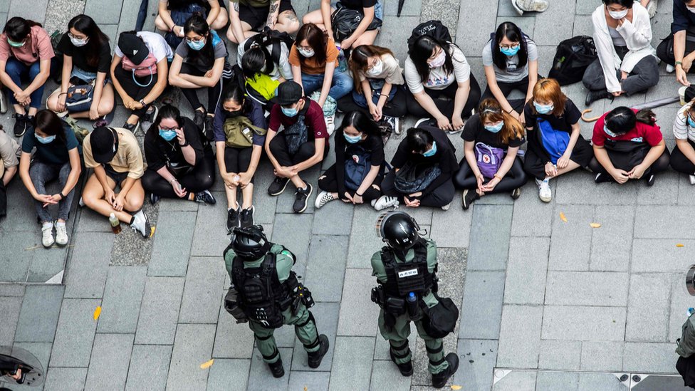 ОМОН задерживает группу людей во время акции протеста в районе Козуэй-Бэй в Гонконге