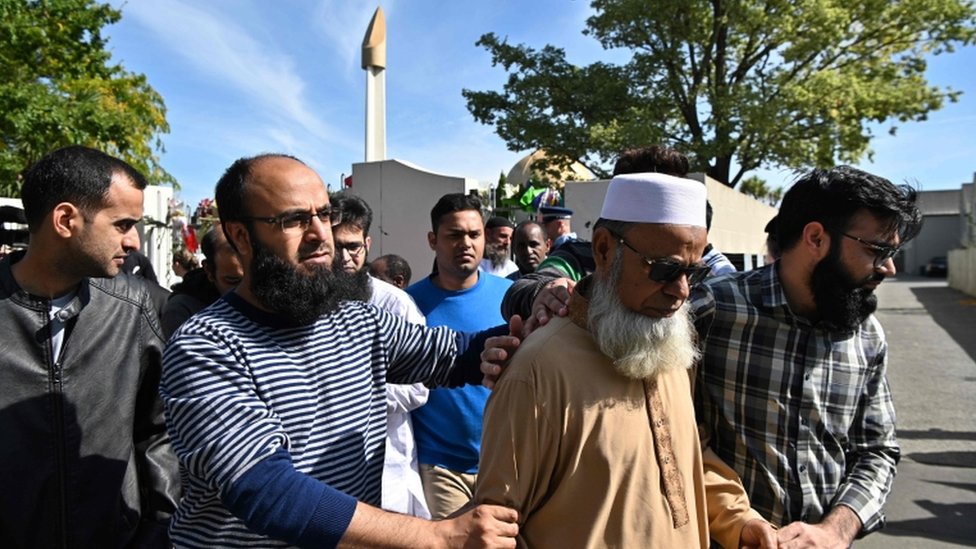 Members of the Muslim community react as they leave the Al Noor Mosque in Christchurch