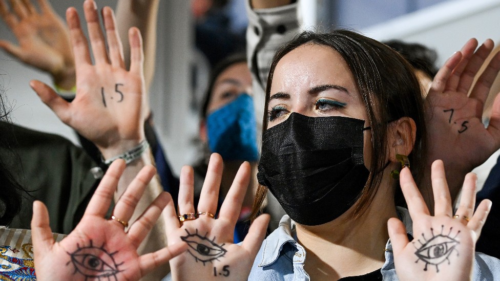 Joven manifestantes con ojos dibujados en las palmas de sus manos
