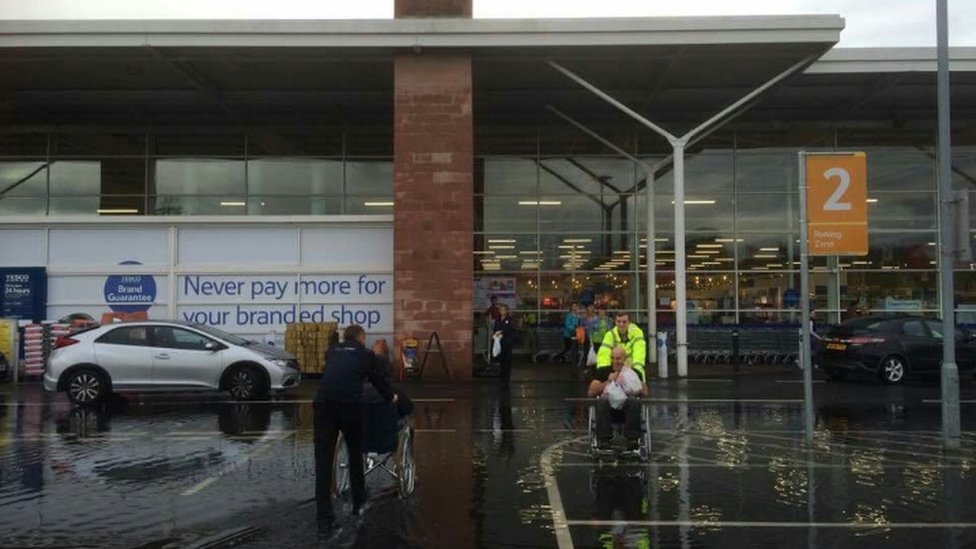 Stafford Tesco uses wheelchairs for flooded shoppers - BBC News