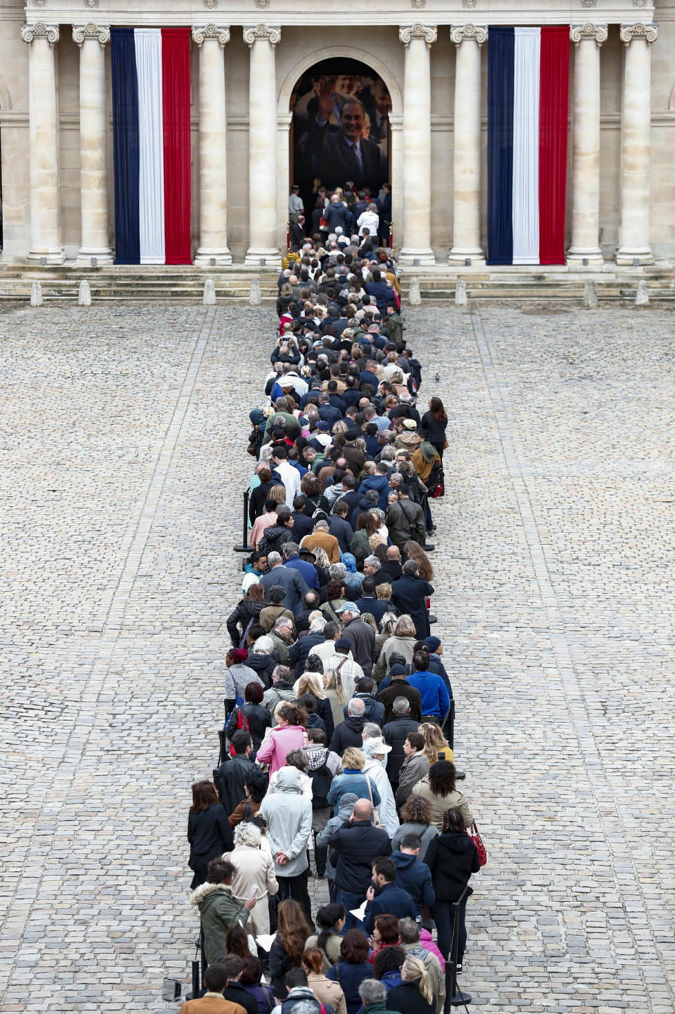 Visitors wait to view the coffin of former French President Jacques Chirac on 29 September 2019.