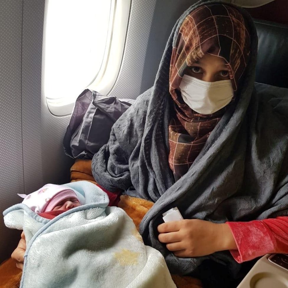 Afghan evacuee Soman Noori holds her newborn baby girl named Havva on board an evacuation flight operated by Turkish Airlines from Dubai to Britain"s Birmingham, August 28, 2021