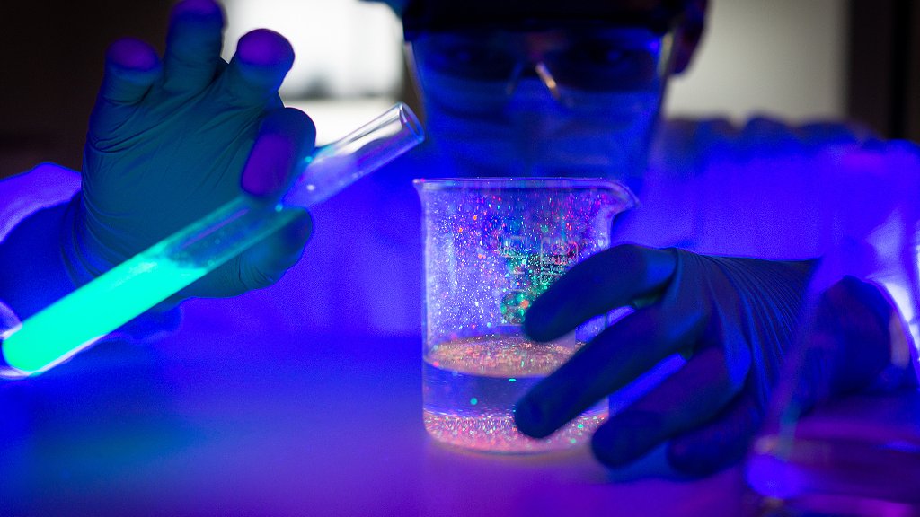 Homem em laboratório misturando substâncias em tubo de ensaio