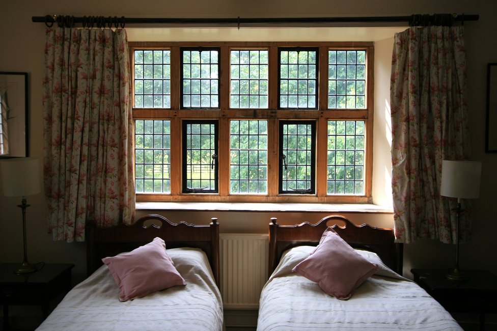 La solución momentánea a la que ha llegado el matrimonio ante el problema es: dormir en camas separadas. Habitación con dos camas individuales en una casa isabelina de Canterbury, Kent, Inglaterra.