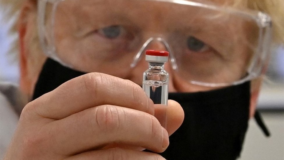 Britain"s Prime Minister Boris Johnson poses for a photograph with a vial of the AstraZeneca/Oxford University COVID-19 candidate vaccine, known as AZD1222, at Wockhardt"s pharmaceutical manufacturing facility in Wrexham, Wales, Britain November 30, 2020.