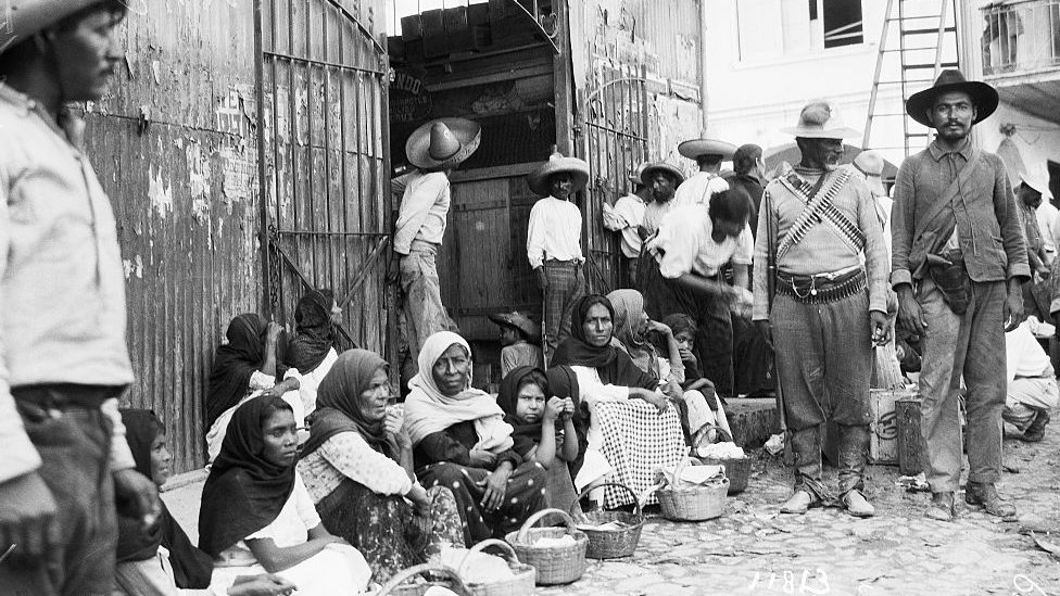 Mujeres, niños y hombres en una plaza de Tampico durante la revolución mexicana.