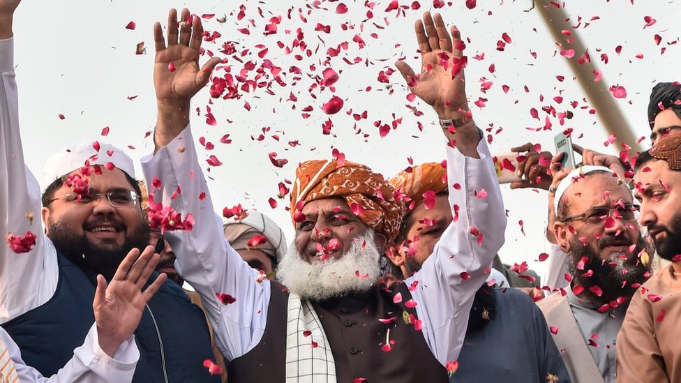 Глава партии «Джамиат улема-и-ислам» Маулана Фазлур Рехман (C) жестом обращается к сторонникам по прибытии во время антиправительственного «марша Азади» в сторону Исламабада в Лахоре 30 октября 2019 г.