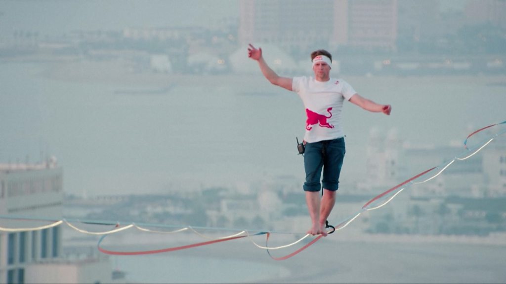 Qatar: Man walks slackline 185m above ground