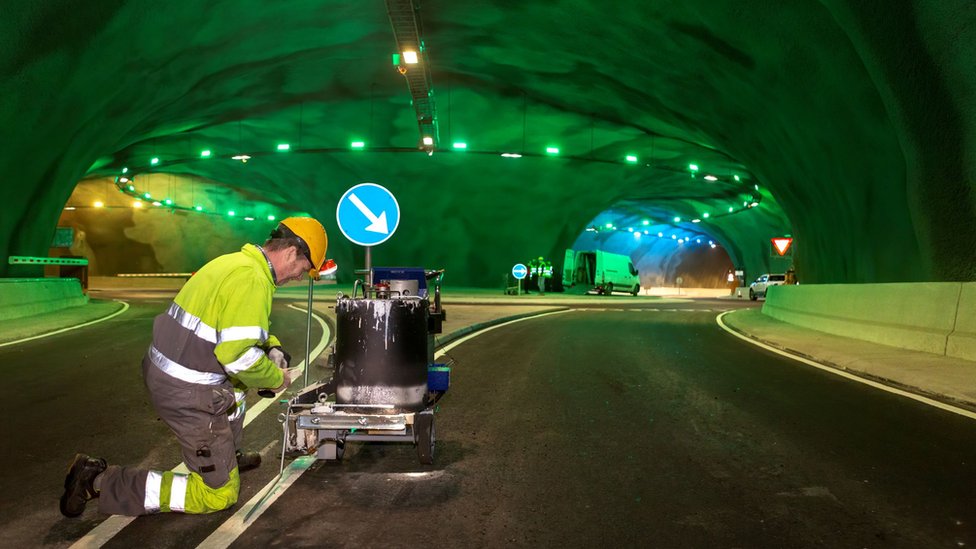 A worker paints road markings inside the tunnel