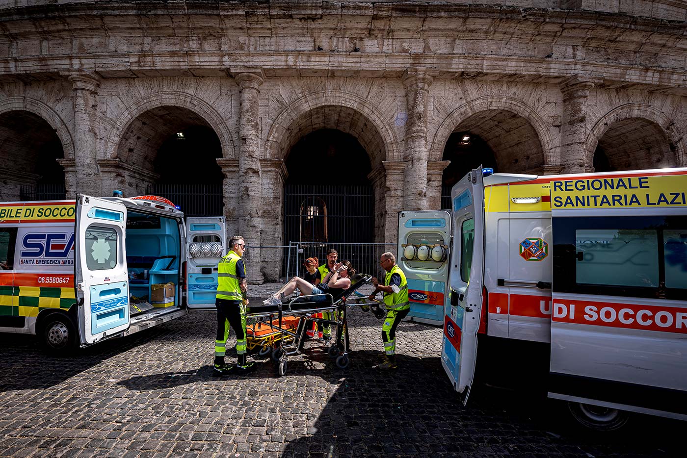 Ambulance workers treat a tourist affected by high temperatures at the Colosseum during a heatwave in Rome - 18 July 2023